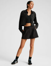 black cropped loose fitting jacket with a collar at neckline, hidden placket with button closure at center front, and front chest cargo pockets.